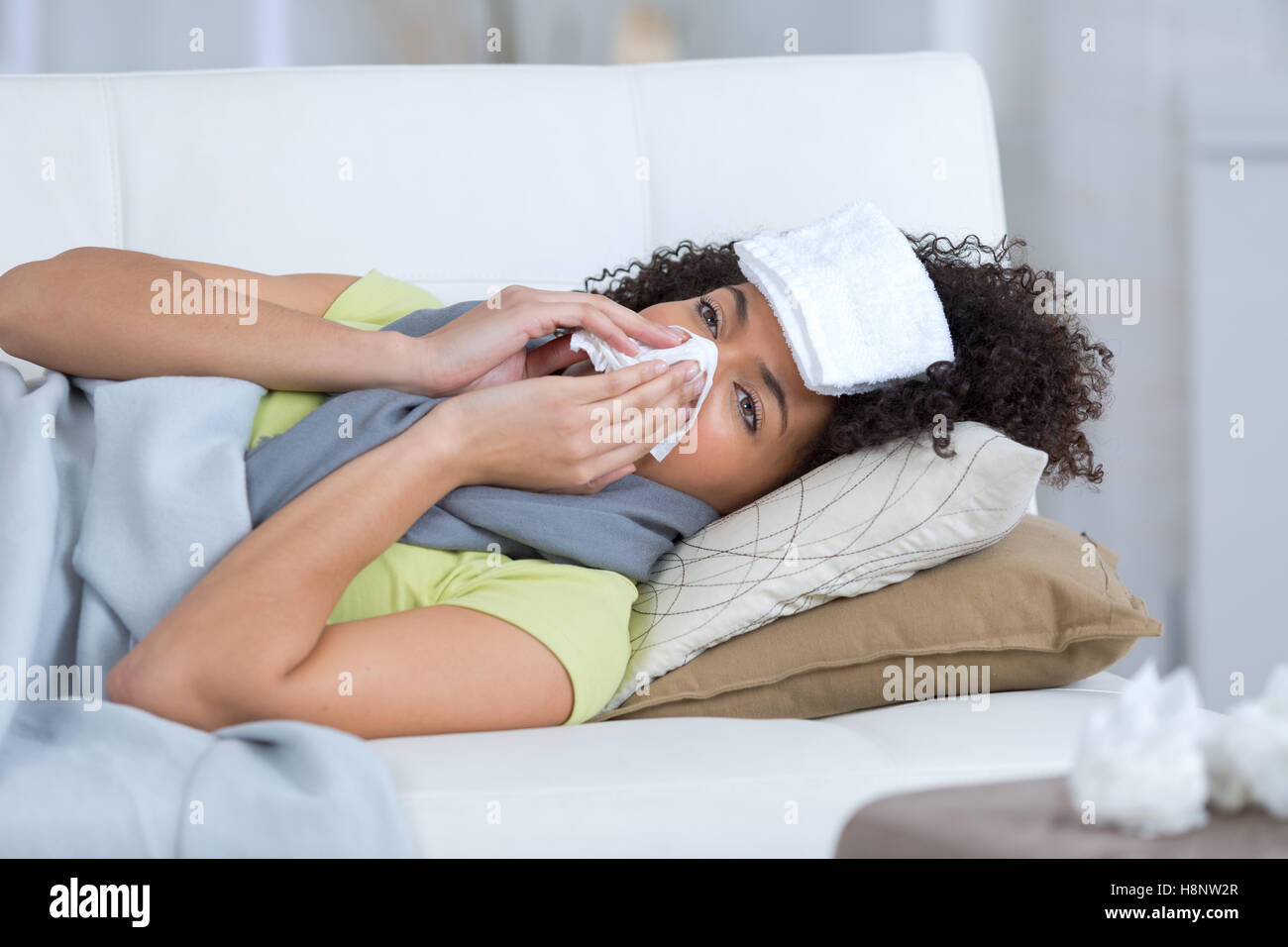a beautiful ill woman siting on the sofa Stock Photo