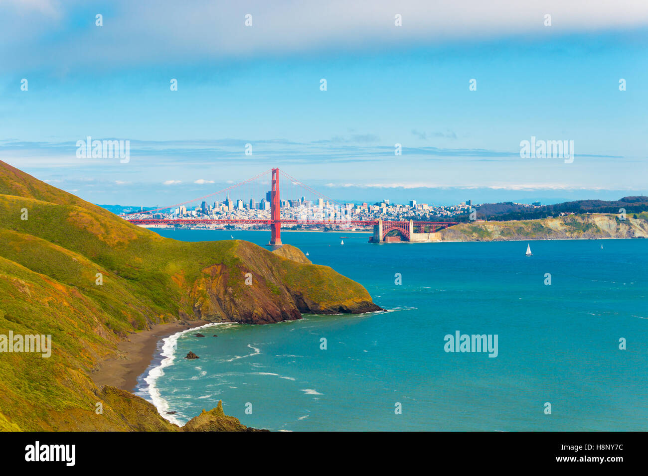 Distant downtown San Francisco cityscape seen through the Golden Gate Bridge together with hills of Marin Headlands Stock Photo