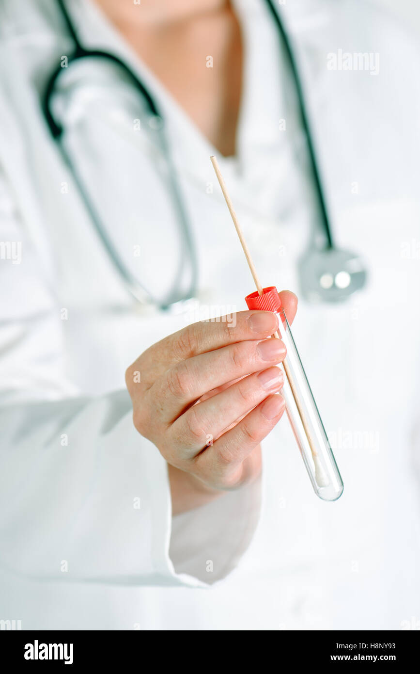 Laboratory test tube with cotton swab in scientist's hand, female