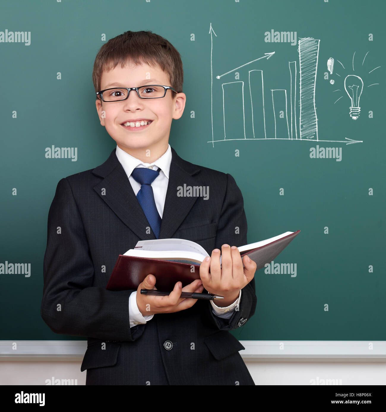 school boy with book, bar chart drawing on chalkboard background