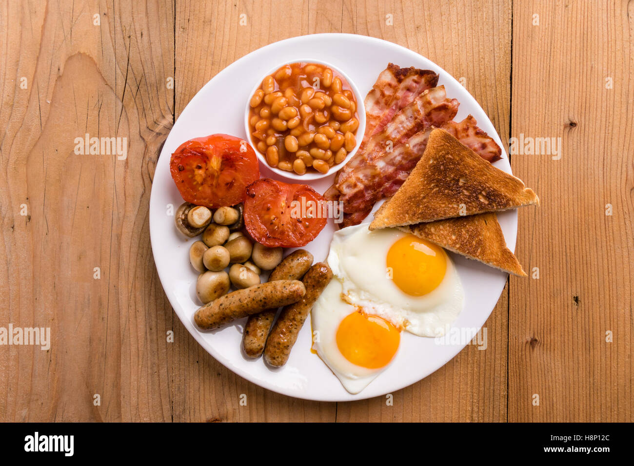 rustic full english breakfast with bacon, sausage, eggs, beans