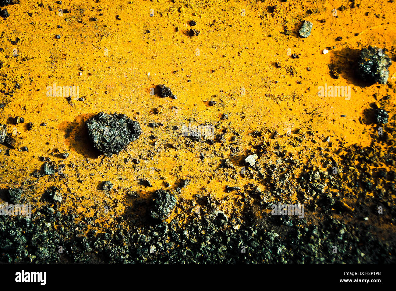 Weathered industrial yellow metal with gravel. Stock Photo