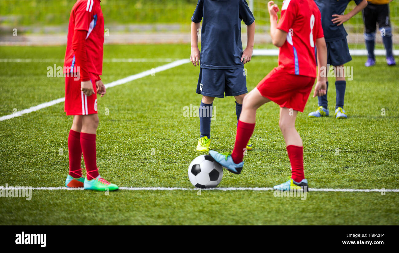 Young boys children in uniforms playing youth soccer football game