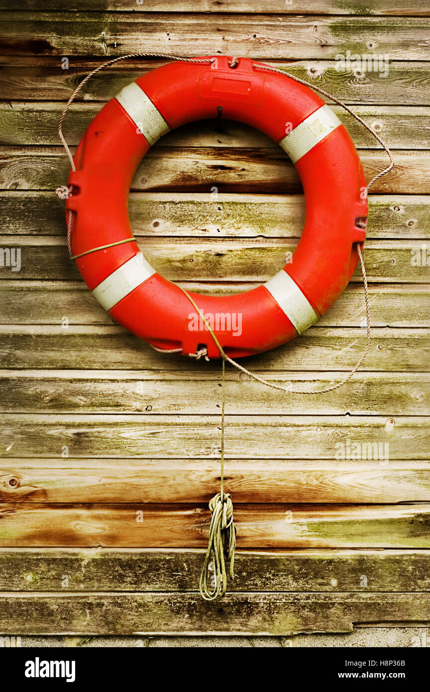 Lifebouy hanging on wooden wall. Stock Photo