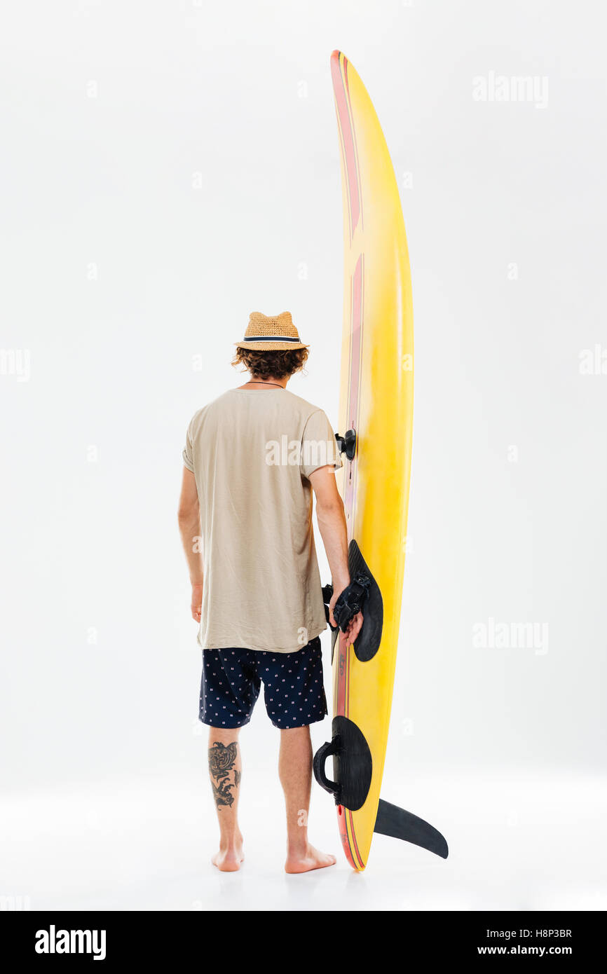Back view a young surfer holding surfboard isolated on the white background Stock Photo