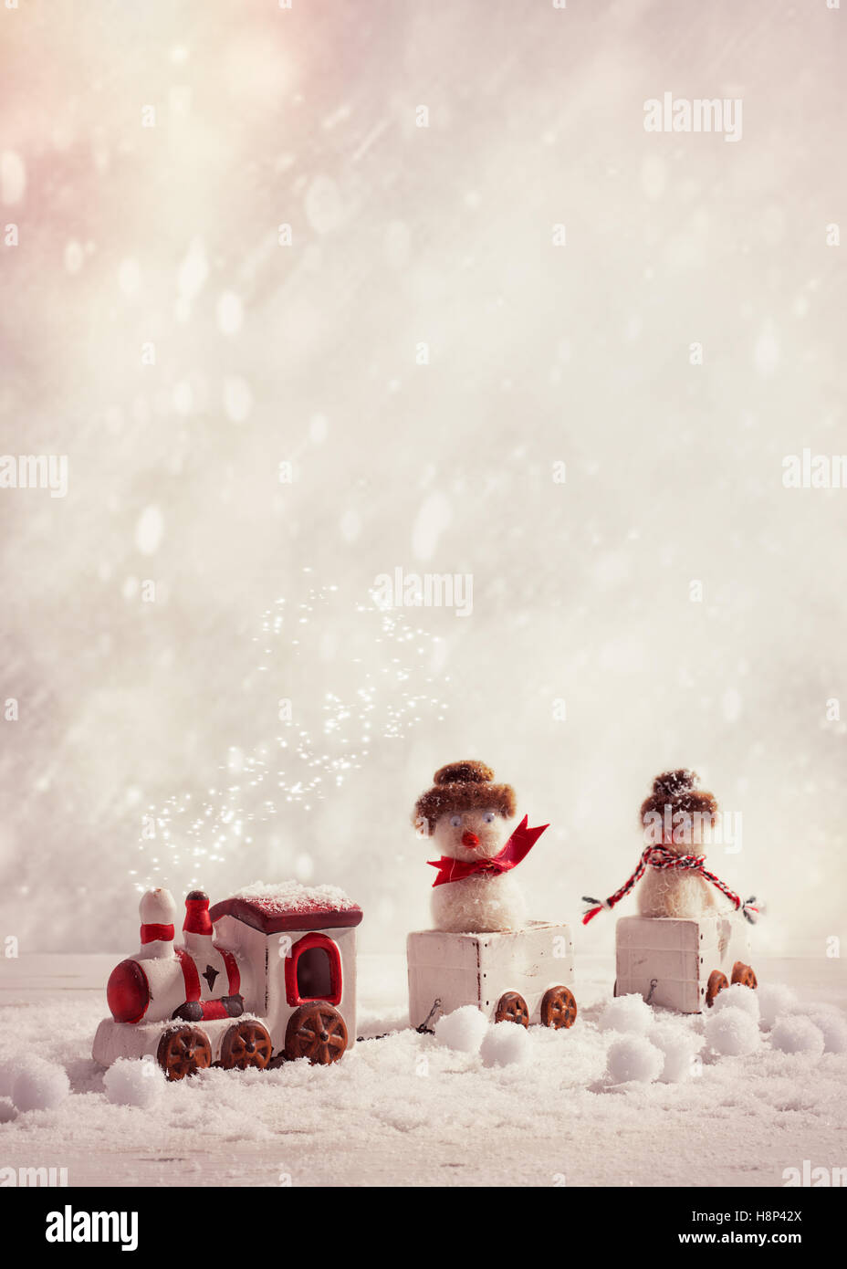 Toy train set carrying snowmen in winter setting with vintage tone - plenty of copy space for text Stock Photo