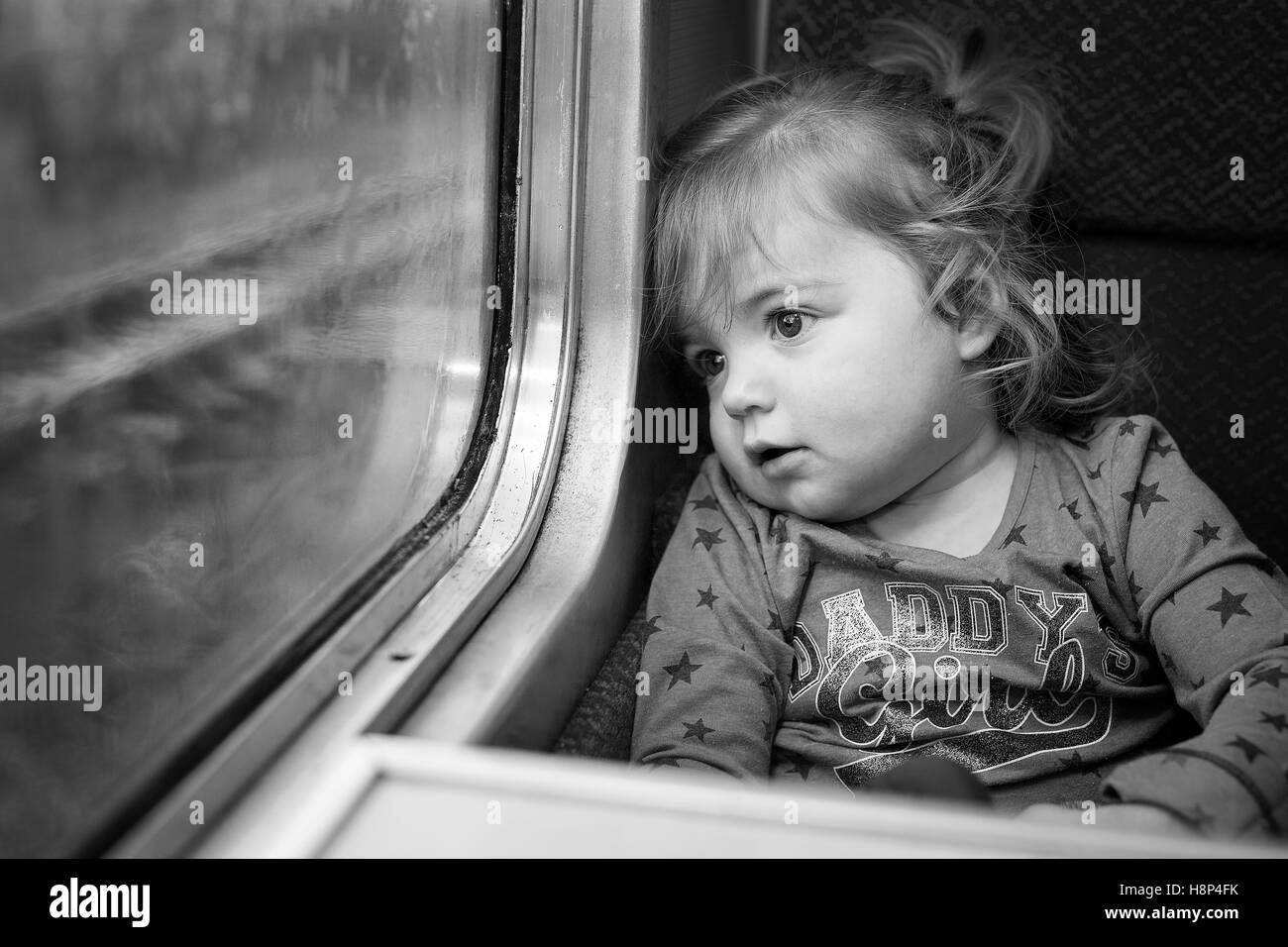 Cute innocent little girl traveling by train in England Stock Photo