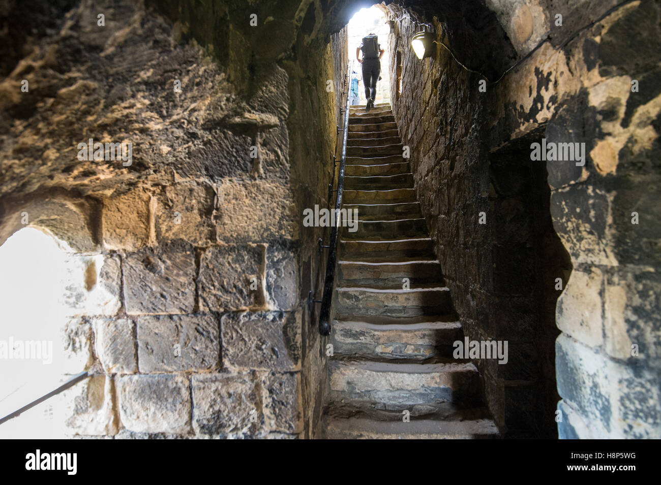 UK, England, Yorkshire, Richmond - A young female tourist climbing a staircase inside the Richmond Castle, one of North Yorkshir Stock Photo