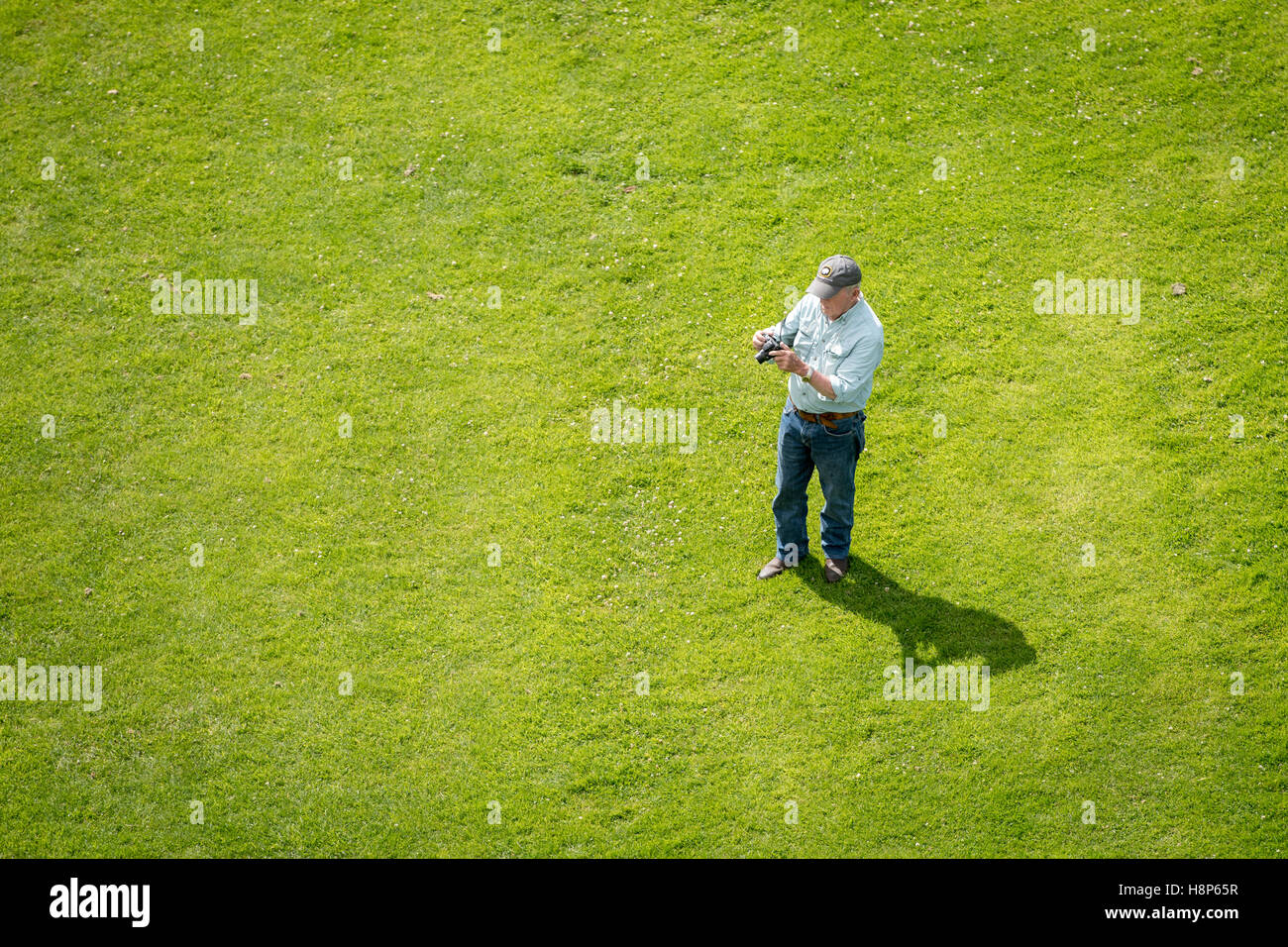 UK, England, Yorkshire, Richmond - An above view of an older male tourist taking pictures on his camera in the city of Richmond Stock Photo