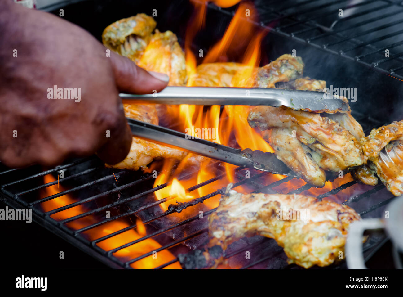 Chef cooking jerk barbecue BBQ chicken on the grill hand turning food Stock  Photo - Alamy