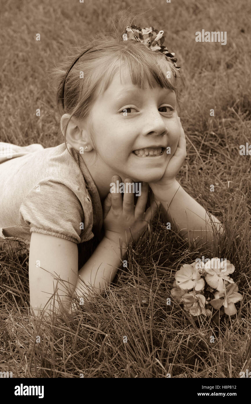young girl laying on ground smiling Stock Photo