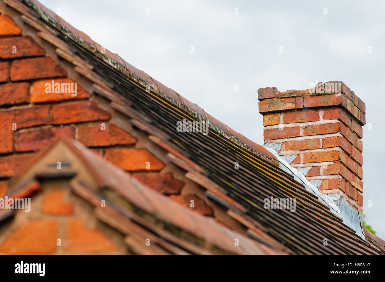 Damaged chimney needs repair old rooftop building exterior Stock Photo