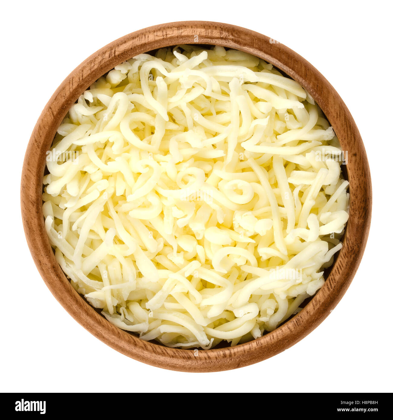 Shredded mozzarella pizza cheese in wooden bowl over white. Cheddar like semi hard Italian cheese made from milk. Stock Photo