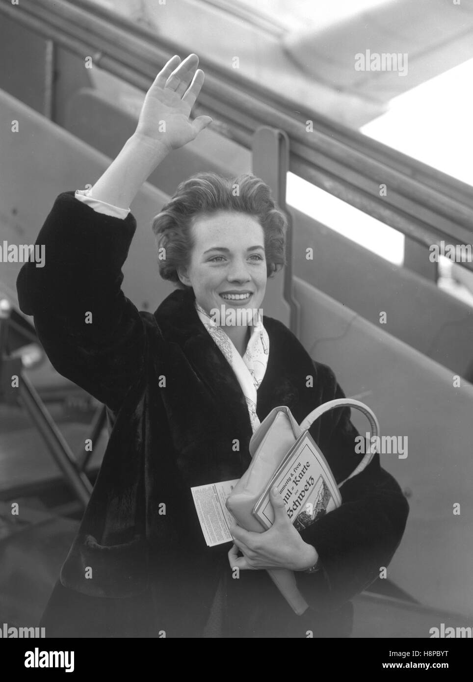 Carrying a map of Switzerland, Julie Andrews waves goodbye at London  Airport as she boards a plane for Zurich on her way for a holiday at  Klosters. She will be back in