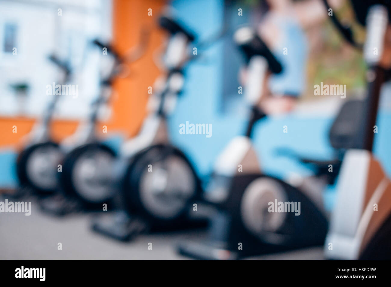 Aerobics spinning exercise bikes gym room with many in a row Stock Photo