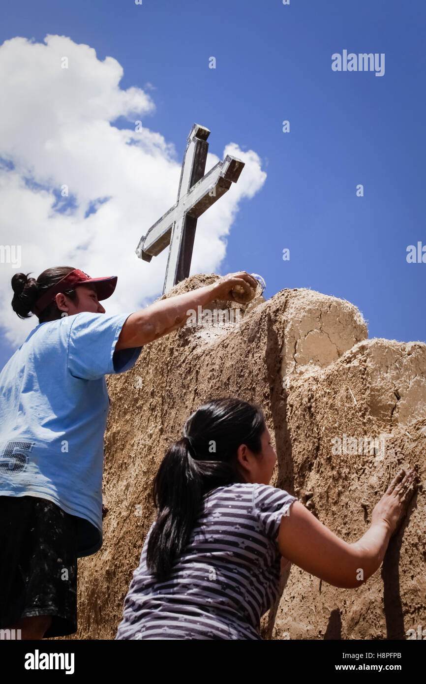 Picuris Pueblo, New Mexico, United States. Local Pueblo residents help repair the church with new mud adobe. Stock Photo