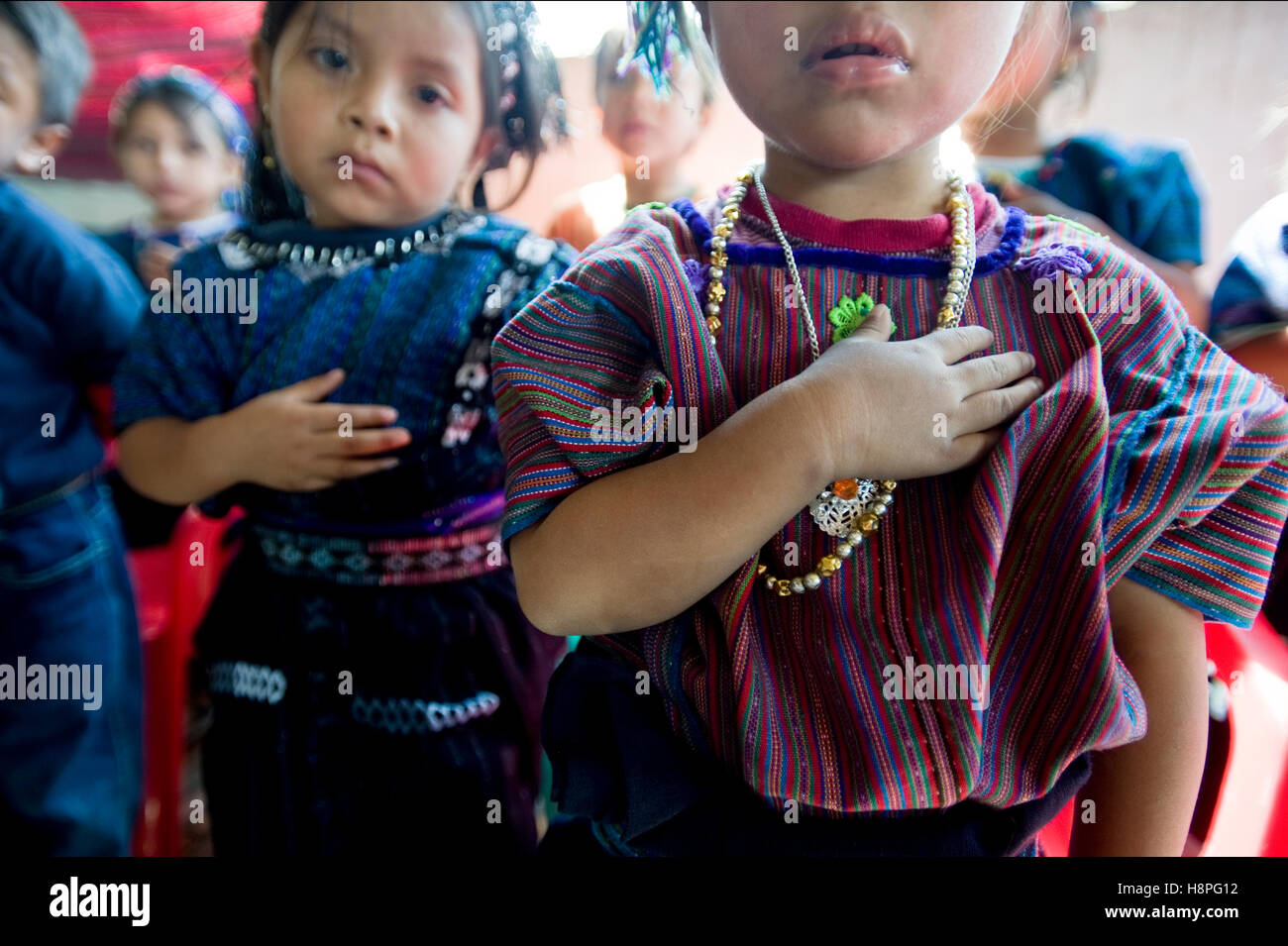 Mayan indigenous children sing national anthem at preschool graduation in San Antonio Palopo, Solola, Guatemala. Stock Photo