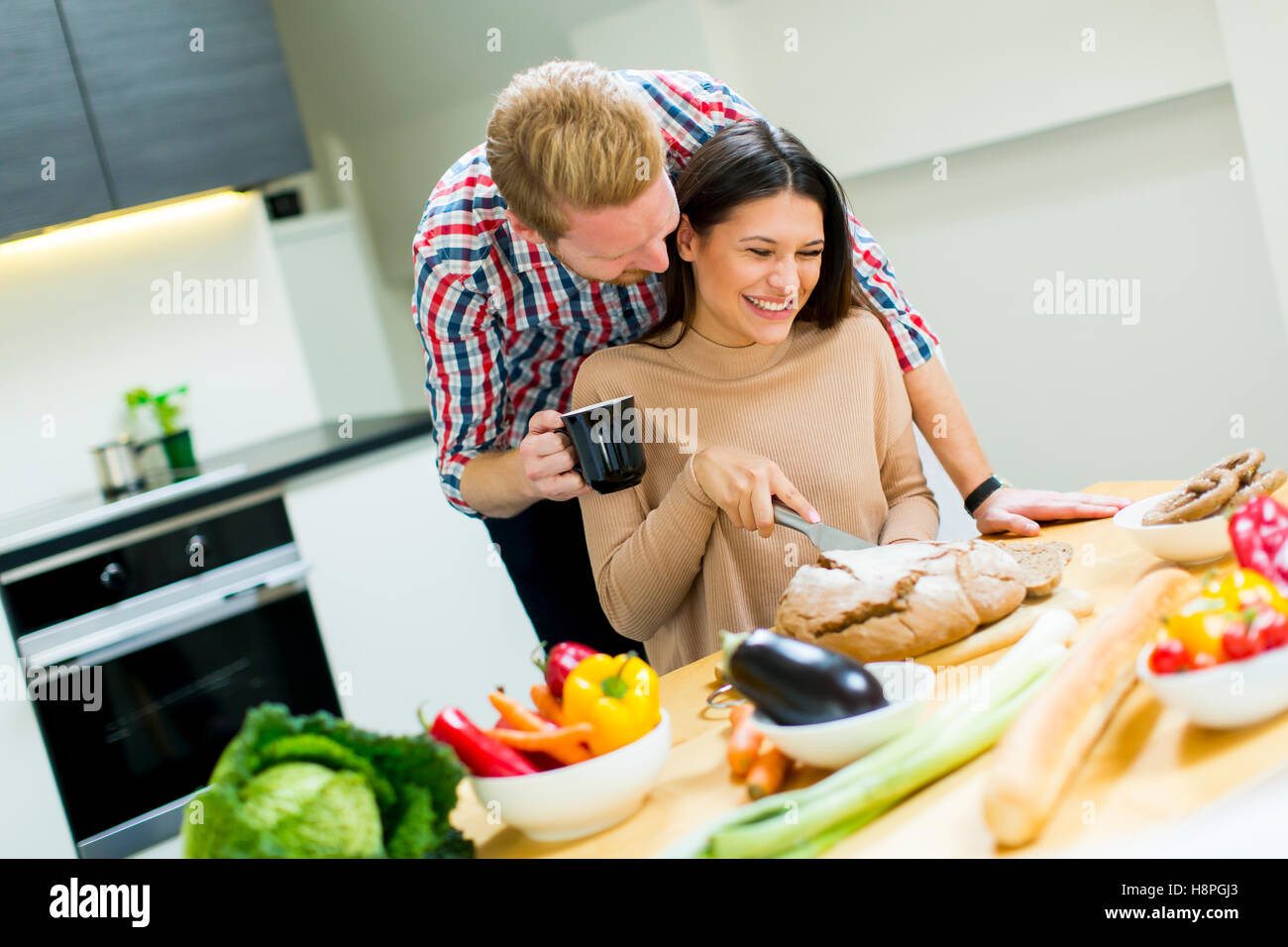 Happy young couple preparing food in the kitchen Stock Photo