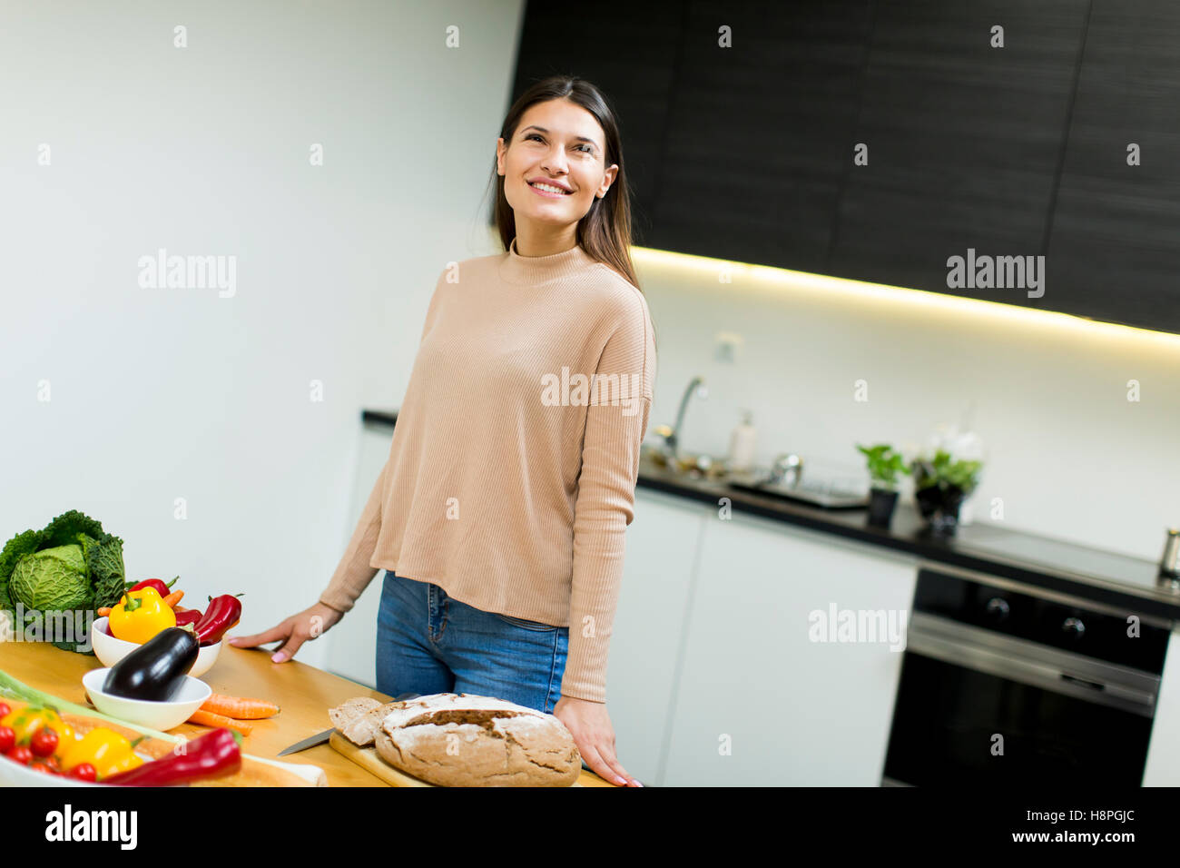 Pretty young woman preparing food in the modern kitchen Stock Photo