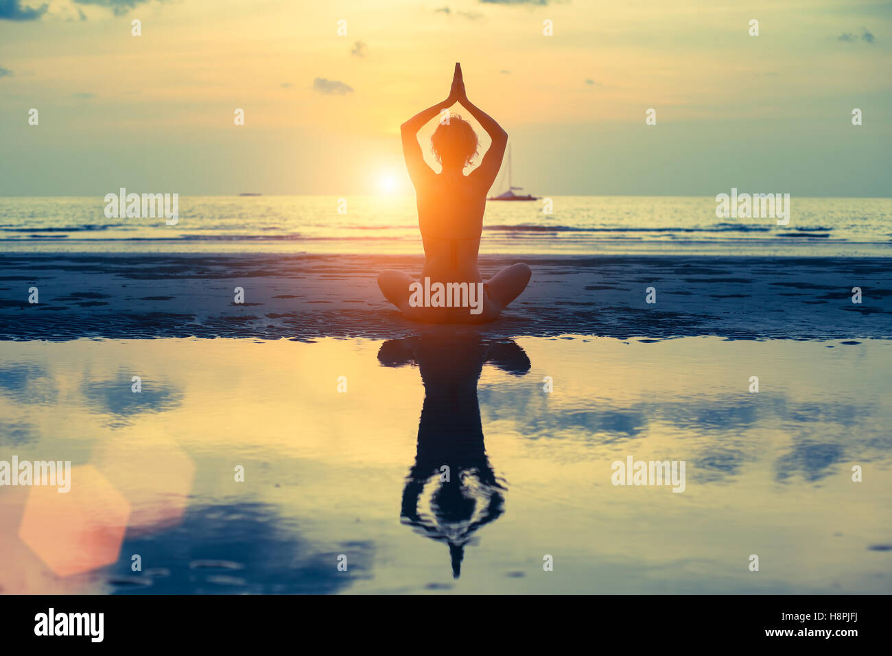 Silhouette woman yoga on the sea beach at sunset Stock Photo - Alamy