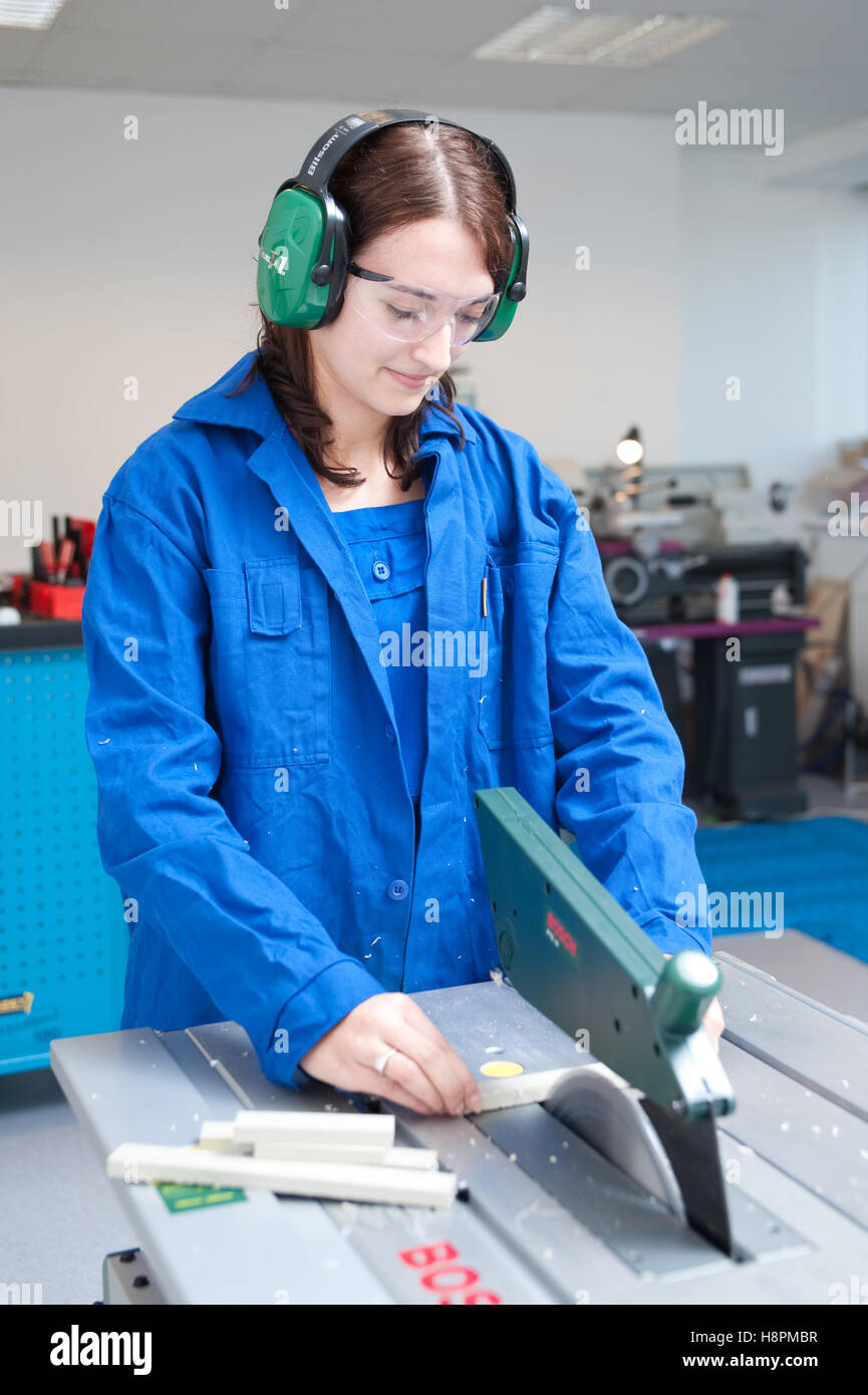 Young woman working at a circular saw bench Stock Photo