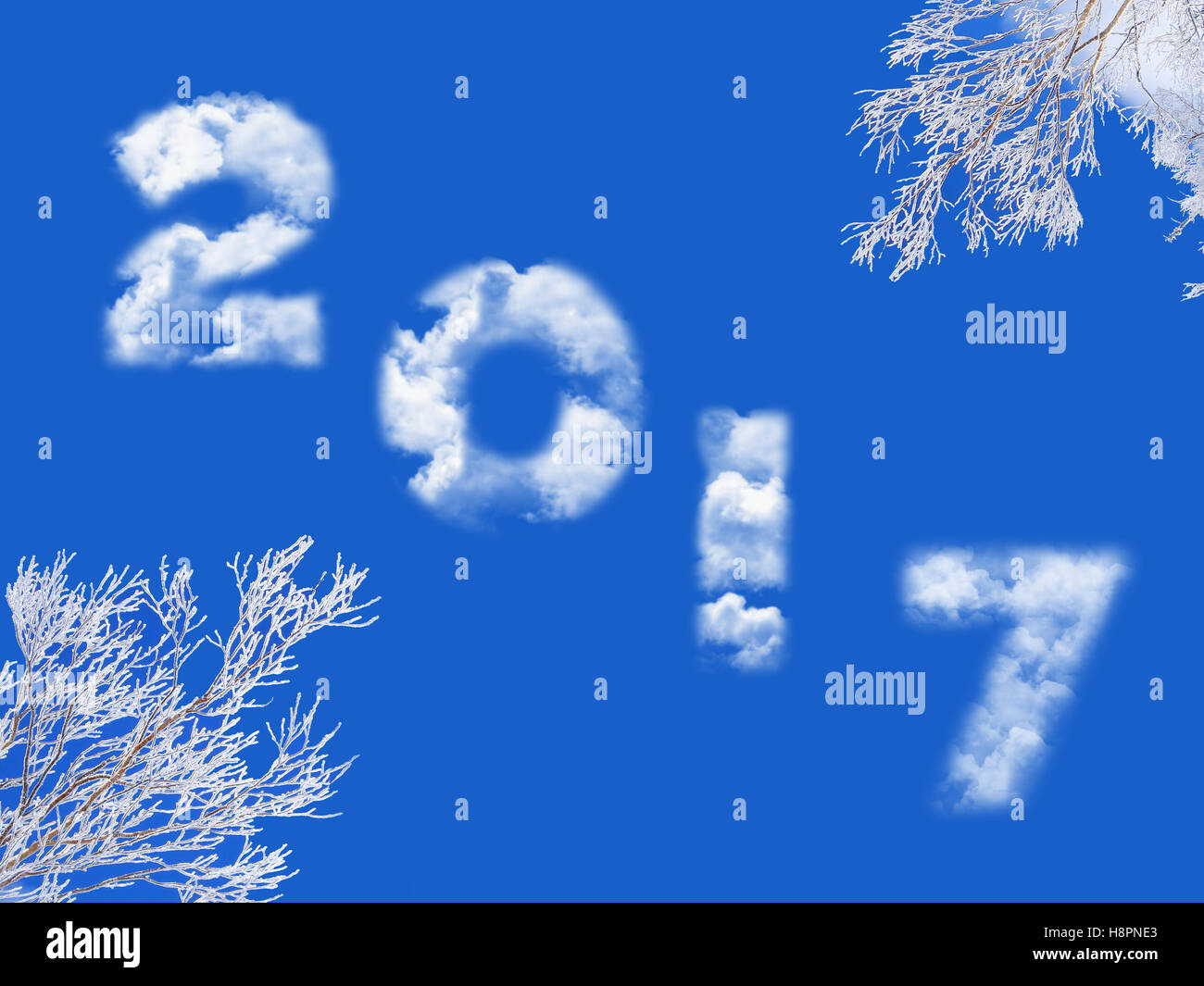 2017 written with clouds, blue sky and snowy tree branches Stock Photo