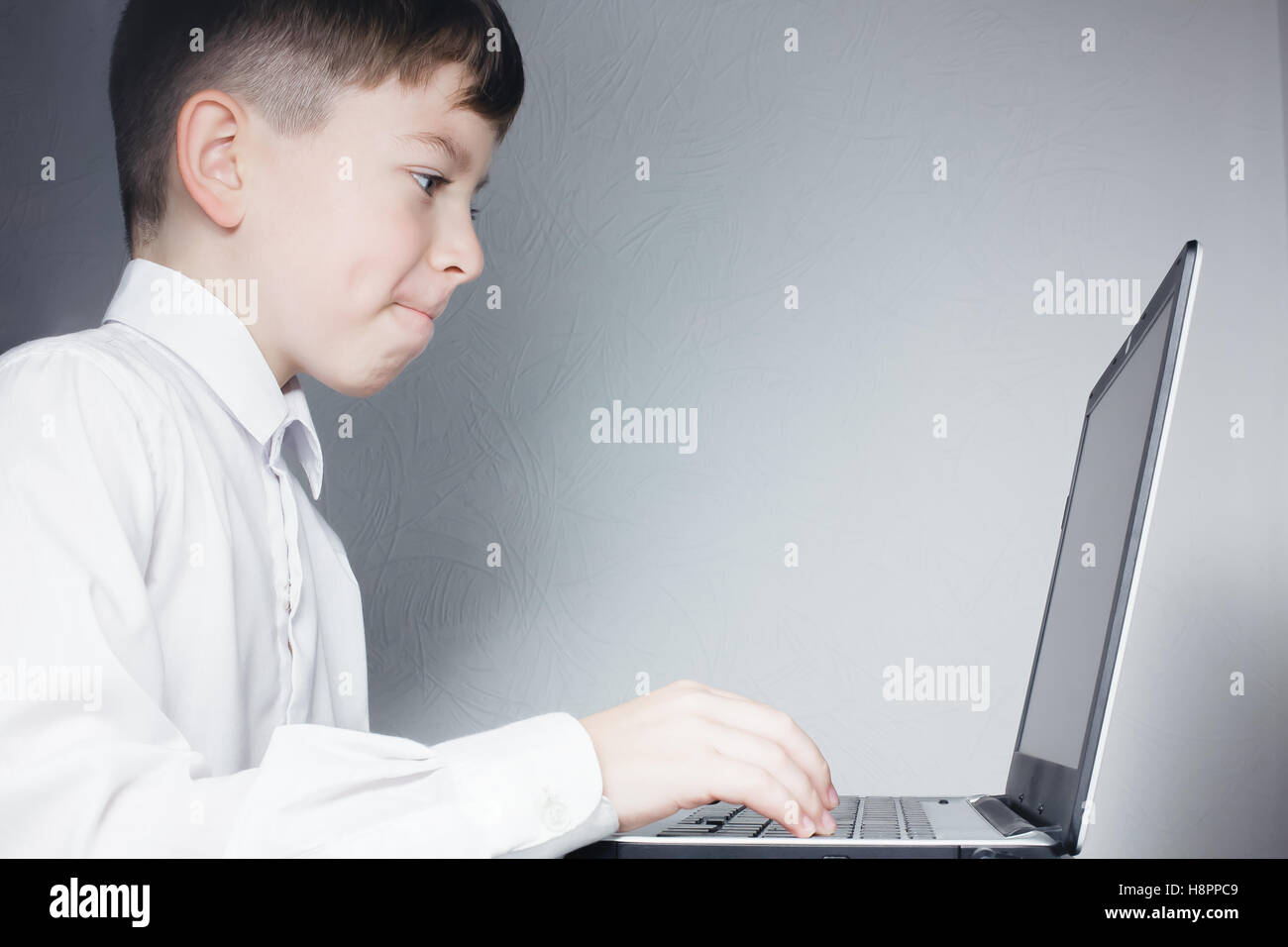 School child looking at computer over gray background Stock Photo - Alamy