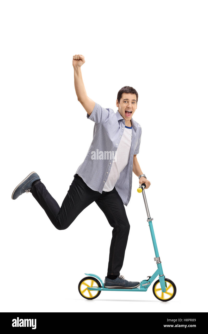 Full length portrait of an ecstatic young man riding a scooter and gesturing with his hand isolated on white background Stock Photo