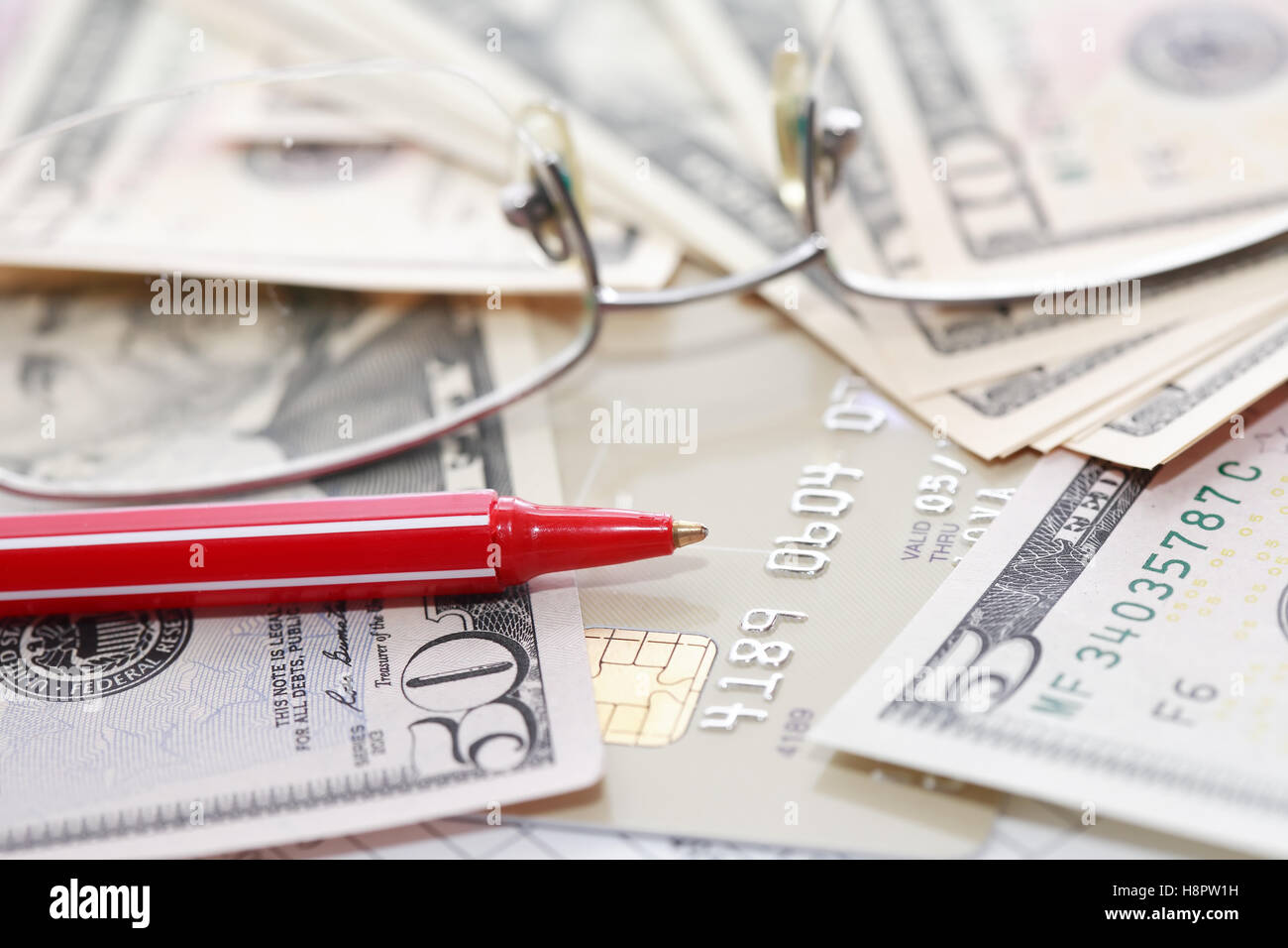 Credit card near money and pen on paper background with digits Stock