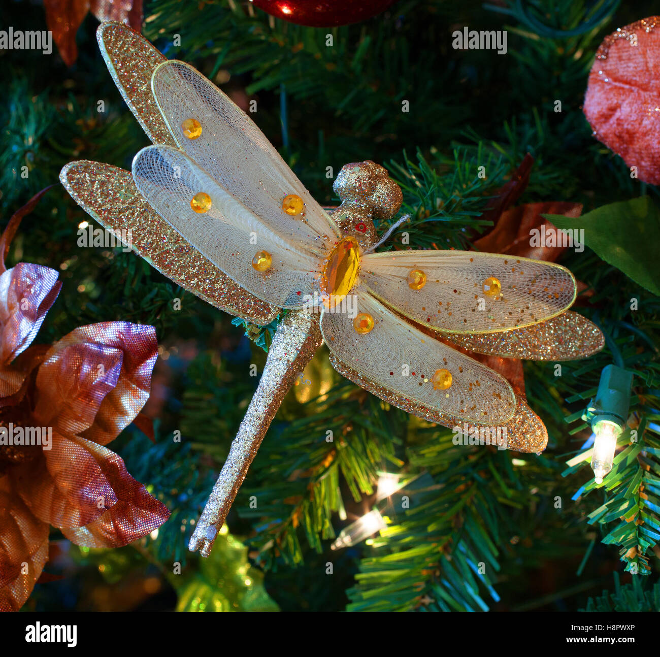 Large dragonfly ornament in an artificial Christmas tree Stock Photo