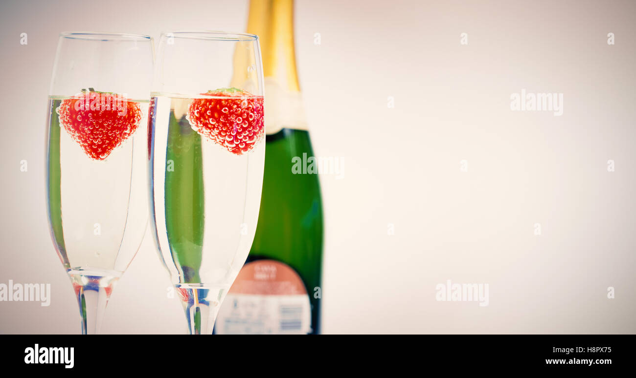 Two champagne flutes with floating strawberries Stock Photo