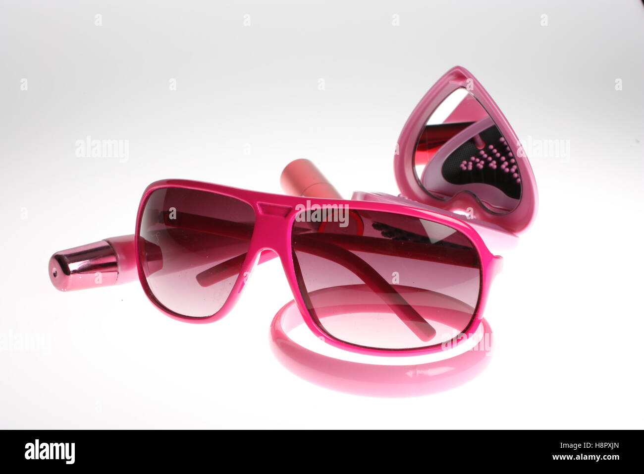Pink still life items pink glasses, bracelet, lipstick and lipgloss Stock Photo