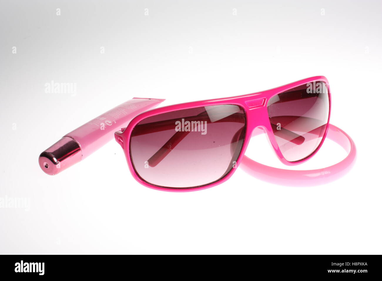 Pink still life items pink glasses, bracelet, lipstick and lipgloss Stock Photo