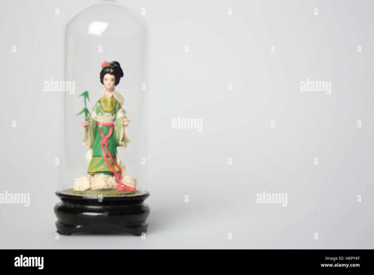 Still life chinese figure in a glass container beautiful delicate sculpture Stock Photo