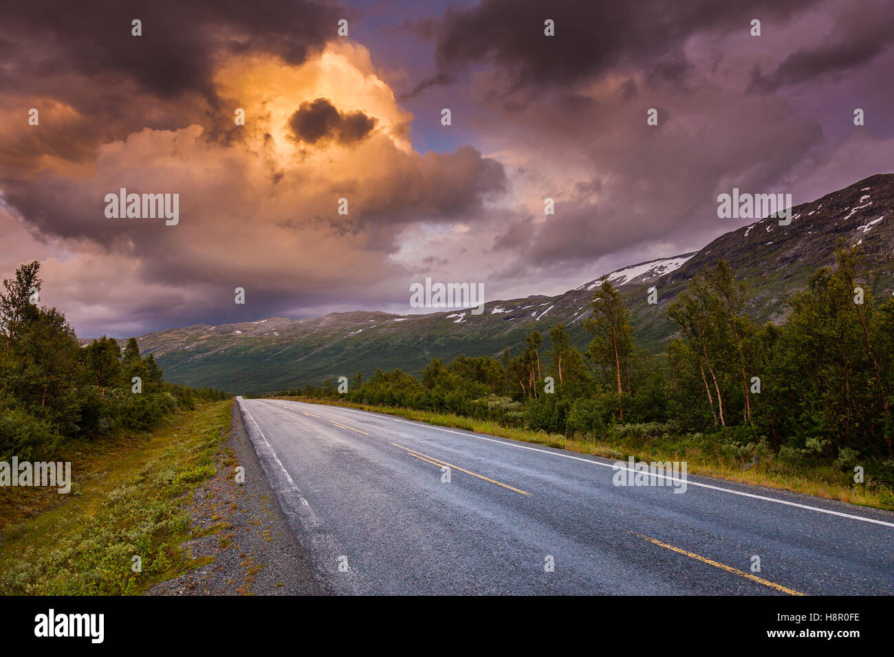 Straight freeway driving way, route to perspective and stormy cloudscape at twilight heaven Stock Photo