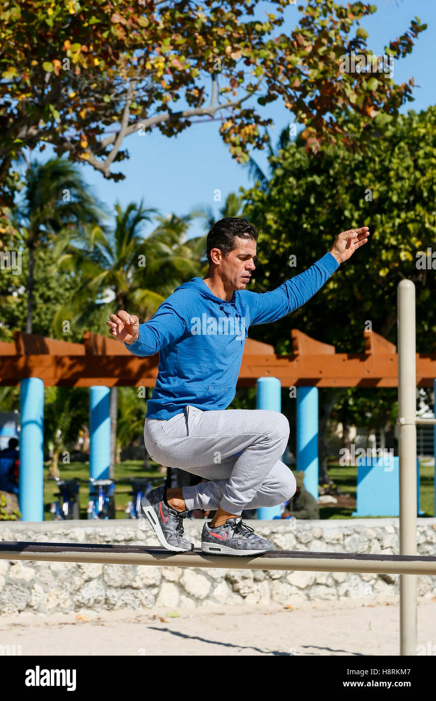Miami Beach, Florida.  Man balances on work out beam at South Beach Stock Photo