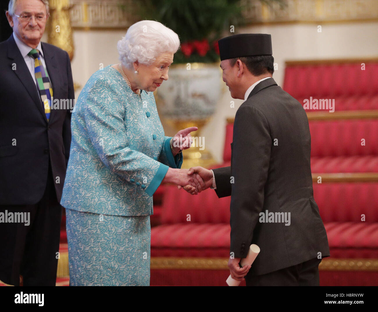 The High Commissioner for Brunei, Darussalam, His Excellency Major General (Rtd) Dato Paduka Seri Haji Aminuddin Ihsan Bin Pehin Orang Kaya Saiful Mulok Dato Seri Paduka Haji Abidin, is presented with a certificate by Queen Elizabeth II during an event at Buckingham Palace, London, to showcase forestry projects that have been dedicated to the new conservation initiative - The Queen's Commonwealth Canopy (QCC). Stock Photo