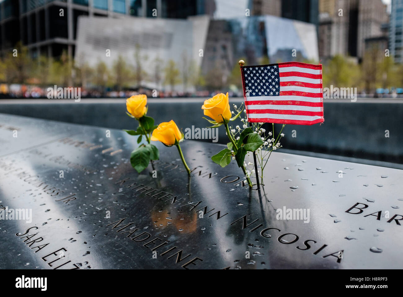 USA Flag and Carnations on the National September 11 Memorial in New York Stock Photo