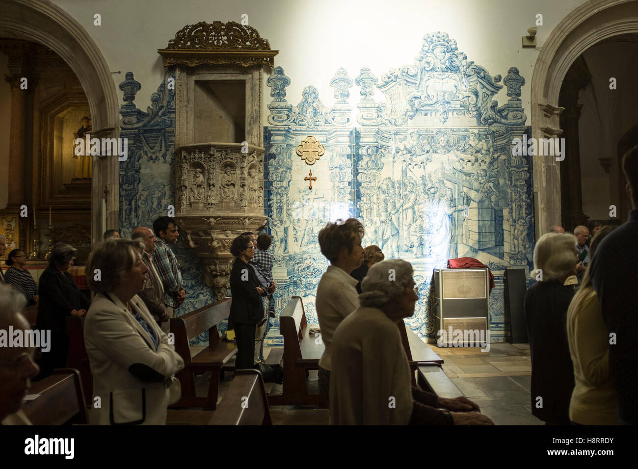 People praying in the igreja de Santa Cruz church in Coimbra, Portugal, during catholic mass Stock Photo
