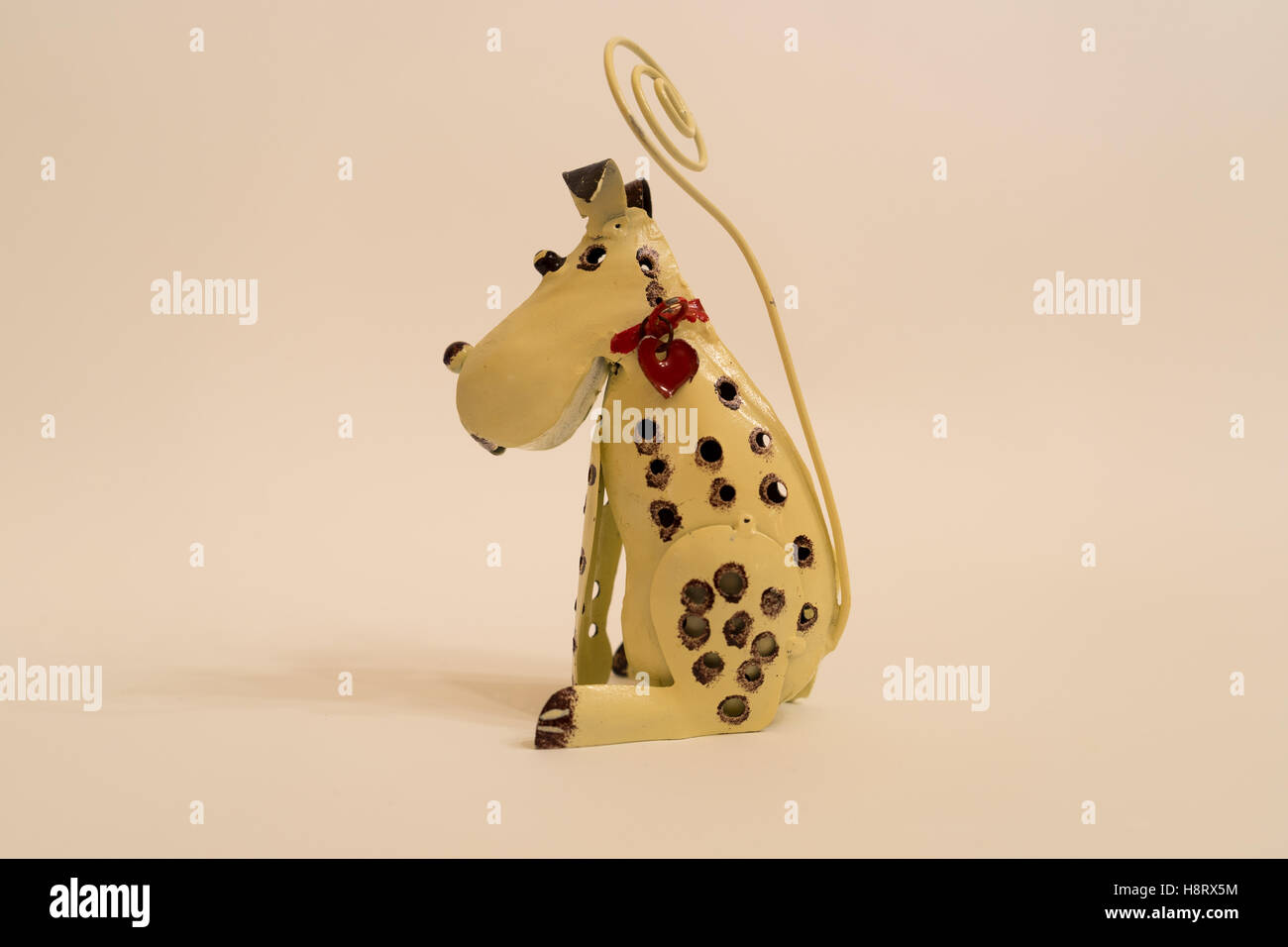 Small metal toy dog with red collar and heart. Stock Photo