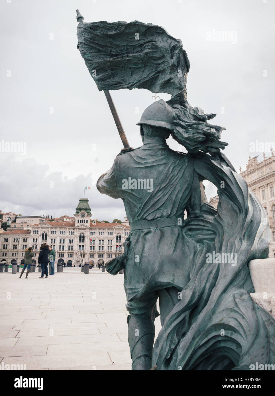 Bronze of Bersagliere soldier statue with flag in Trieste. Sculpture representing solders on the waterfront in Trieste, Italy. Stock Photo