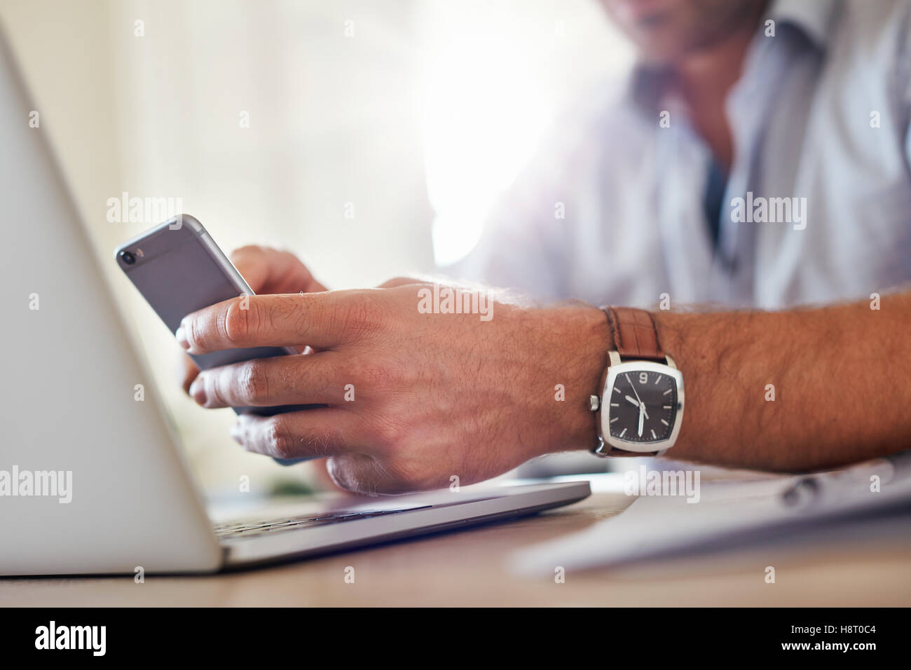 Shot of a man's hands using smart phone. Business man hands busy using mobile phone, focus on the hand and cellphone. Stock Photo
