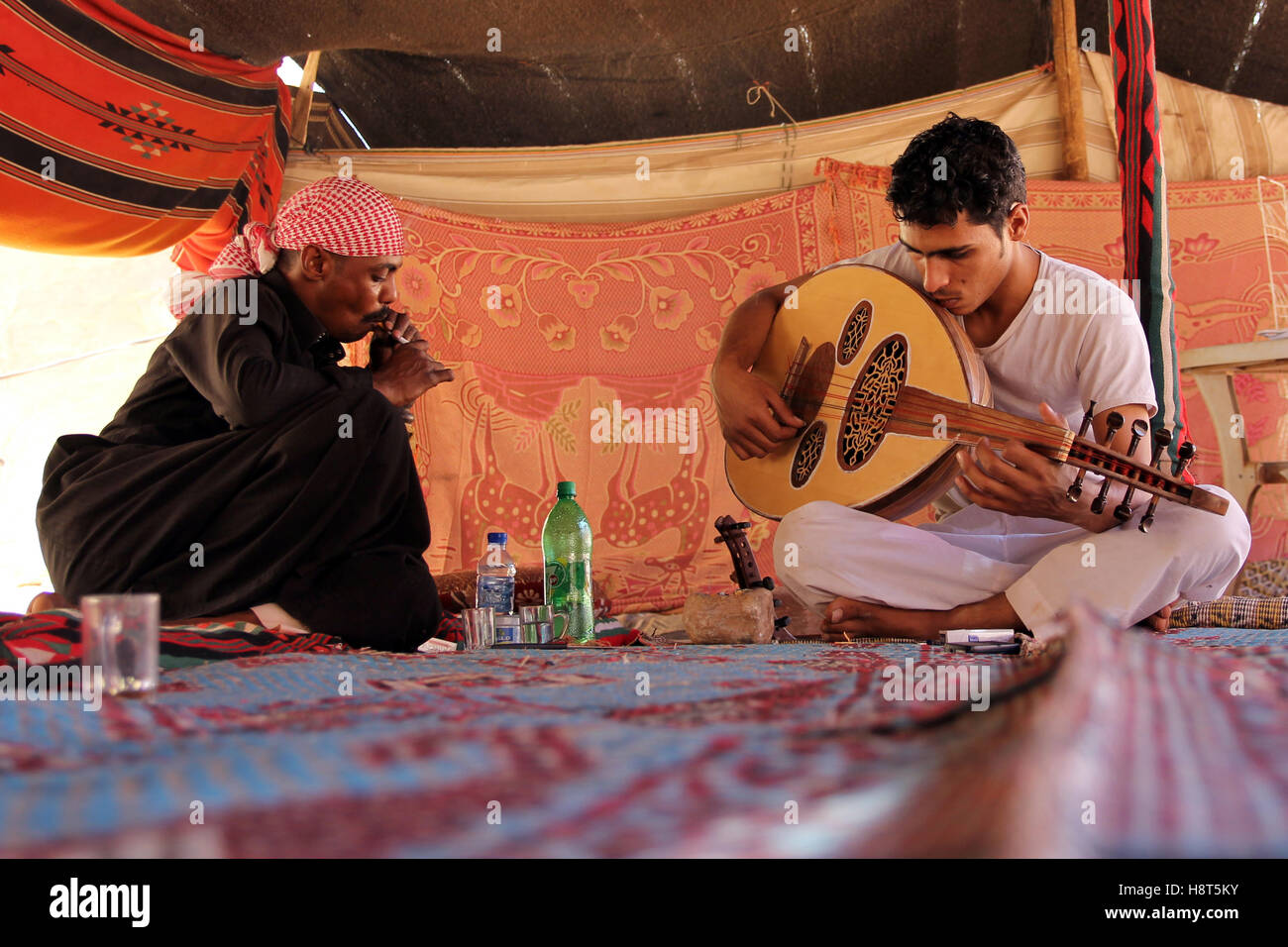 Bedouins playing guitar and smoking in tent, Valley of Wadi Rum, desert in Jordan Stock Photo