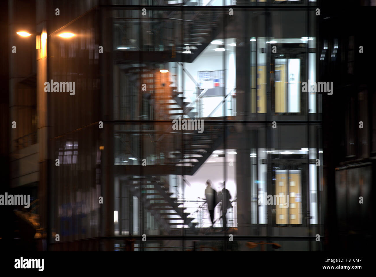 nighttime after hours office glass silhouettes stairs Stock Photo