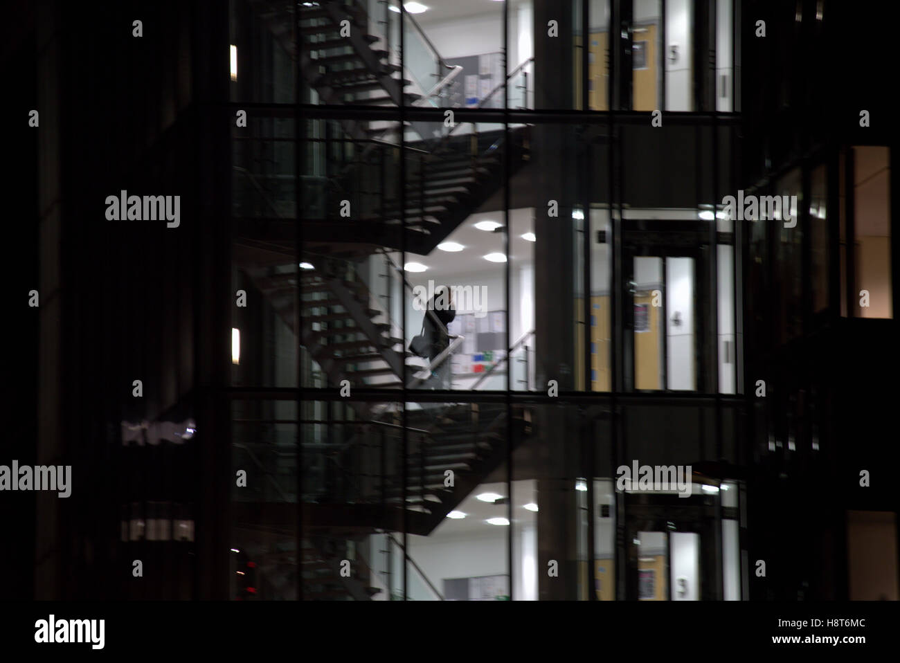 nighttime after hours office glass silhouettes stairs Stock Photo