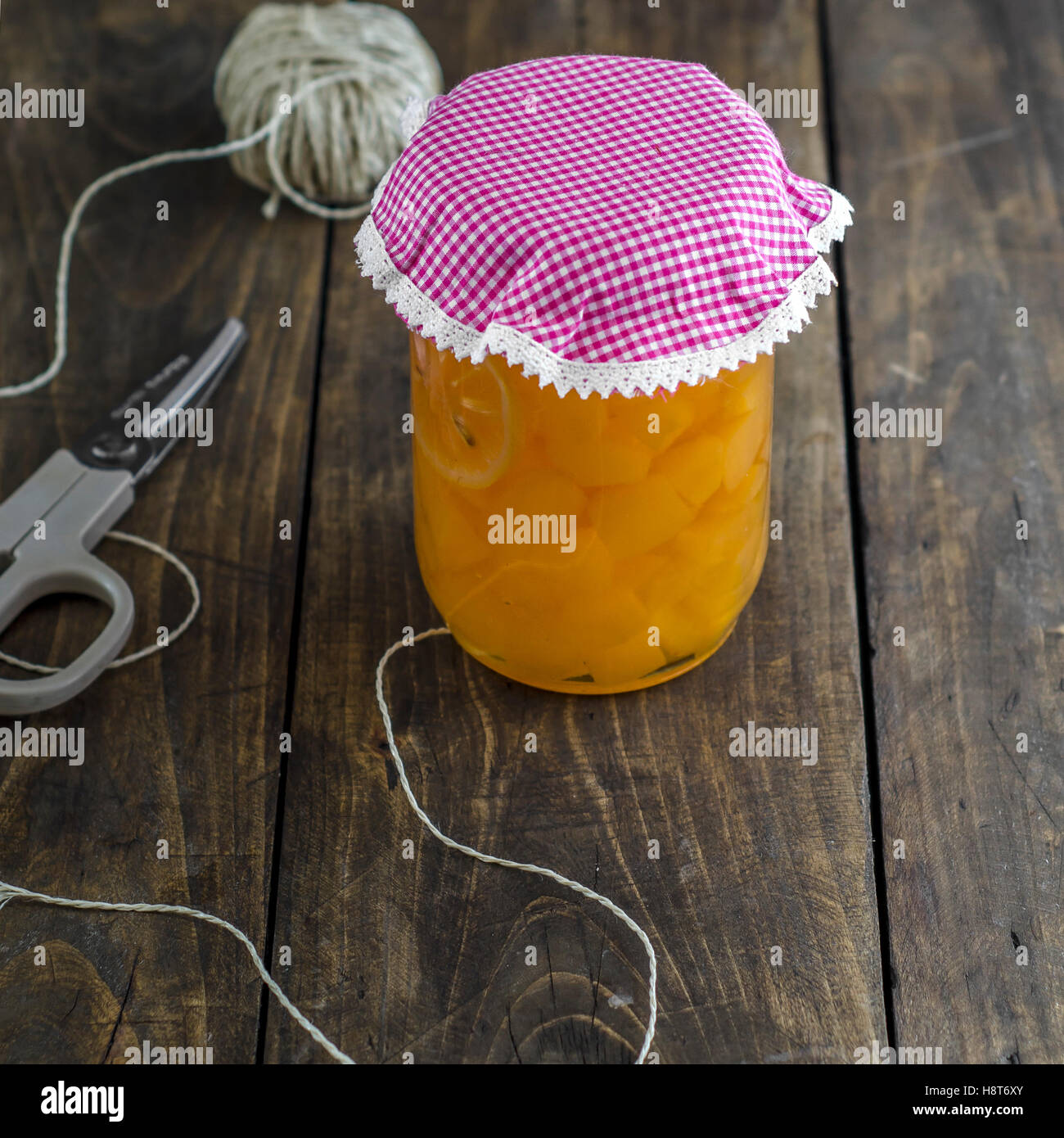 Homemade canned peaches on wooden table. Stock Photo