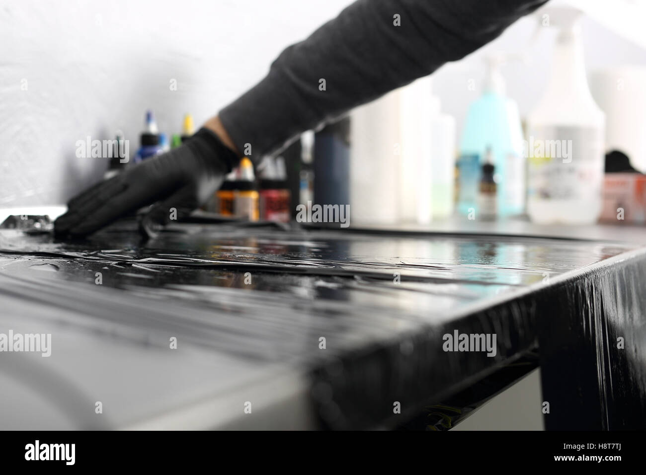 Male tattoo artist assumes black latex gloves Stock Photo Alamy