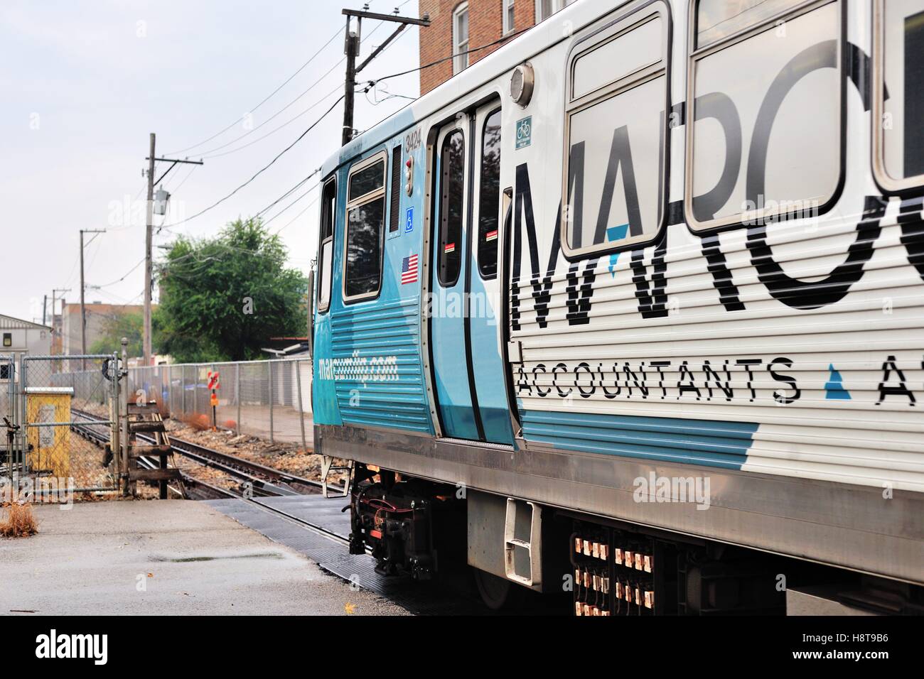 A CTA Brown Line train crossing a city street near Chicago's Francisco