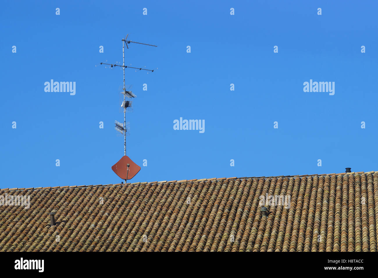 antennas on the rooftops with a background of blue sky Stock Photo