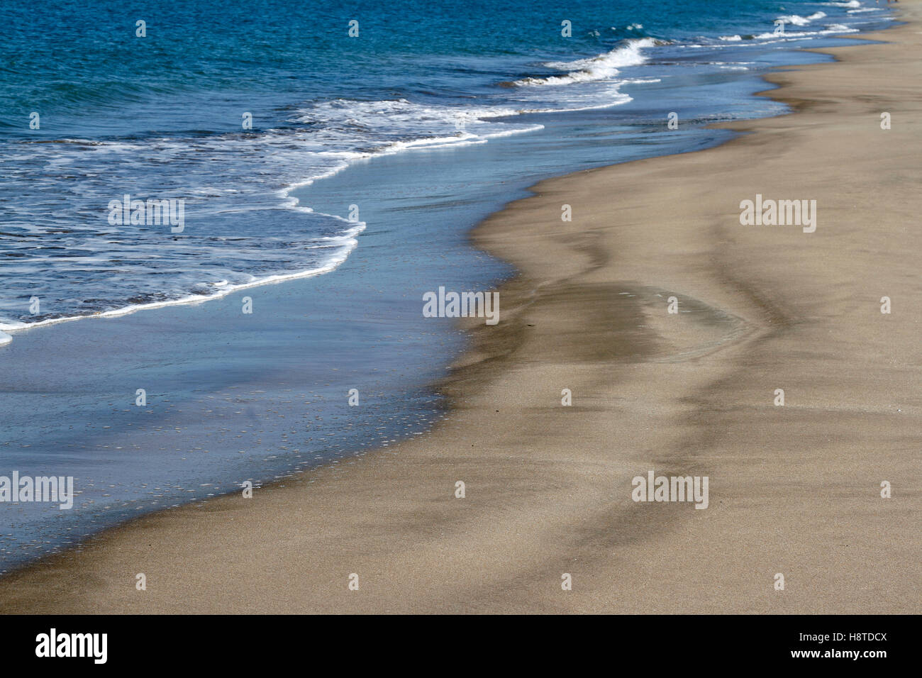 Golden sand and blue water Stock Photo